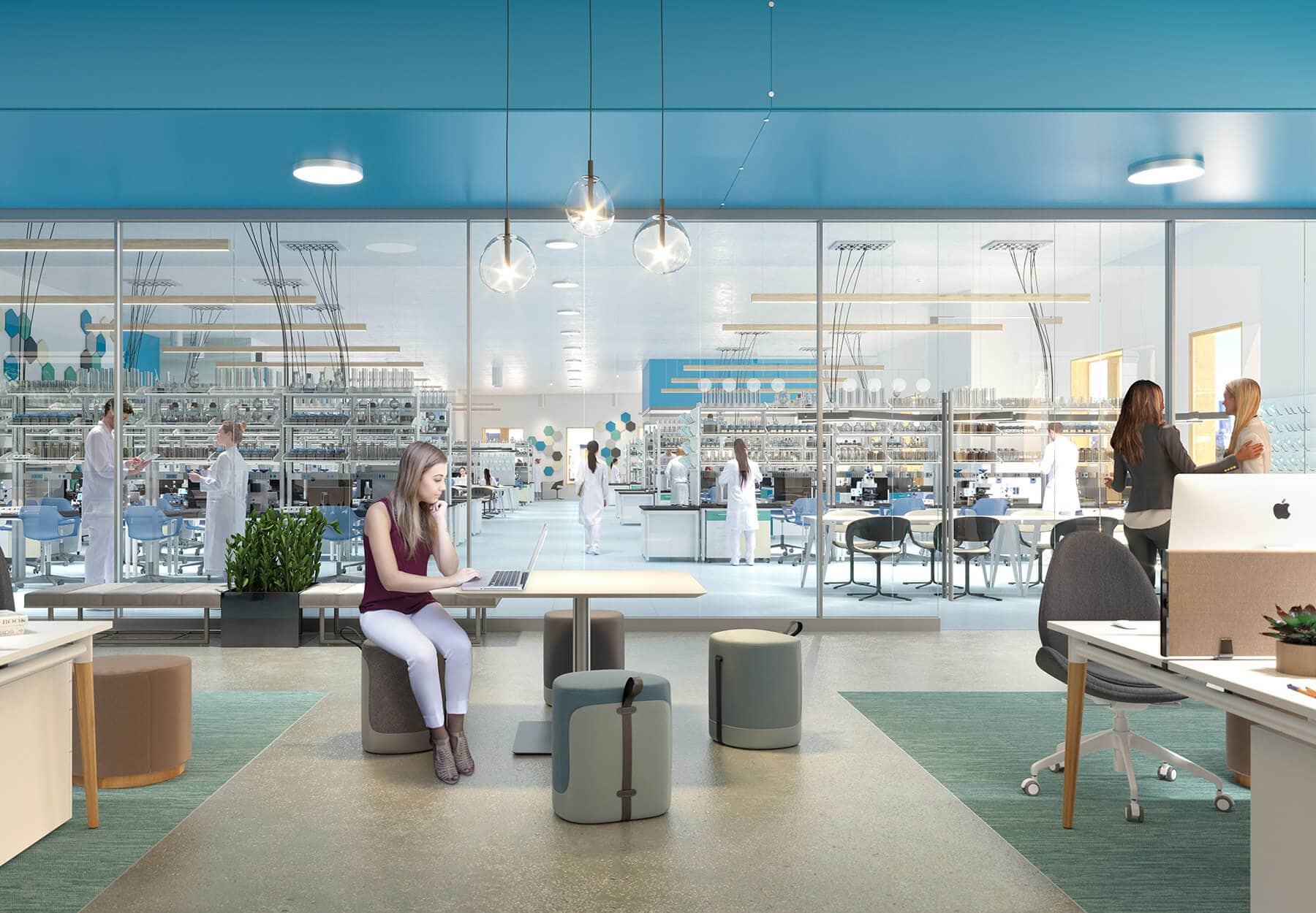 A woman works in an open office space next to adjoining lab space